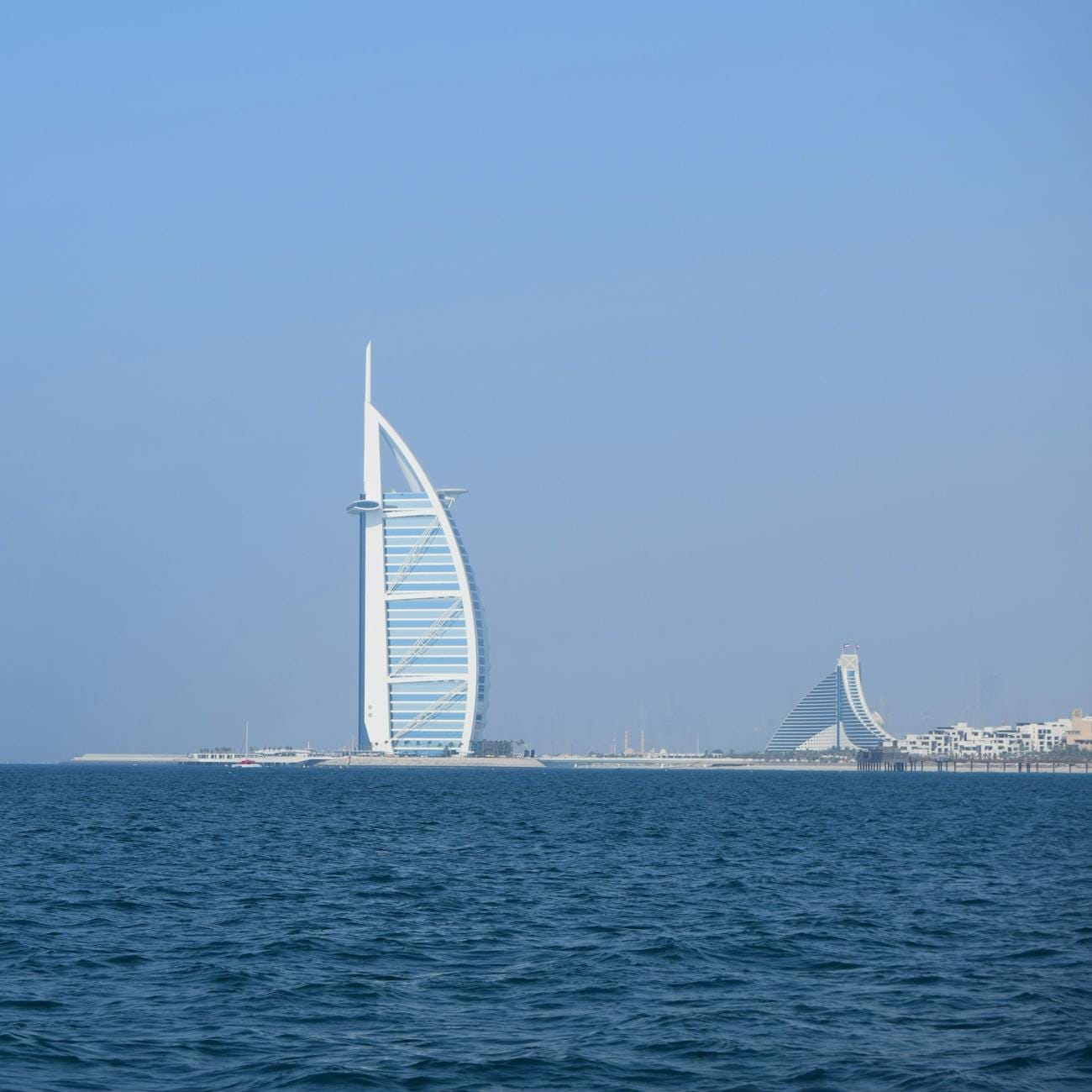 Hotel Burj Al Arab nad morzem w słoneczny dzień w Dubaju