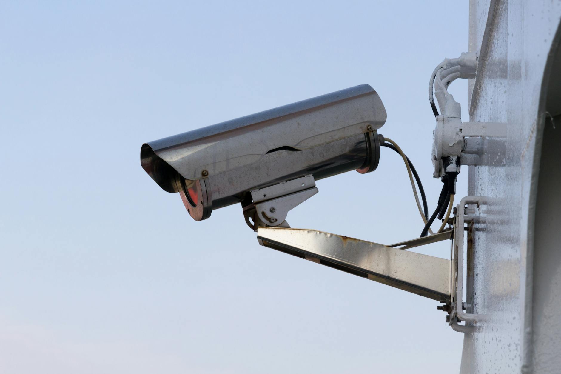 Zbliżenie na zewnętrzną kamerę monitoringu zamontowaną na ścianie