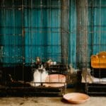 Czarno-biały kot w metalowej klatce z pojemnikiem na wodę