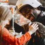 Strażak i dziecko głaszczą kota w środku budynku