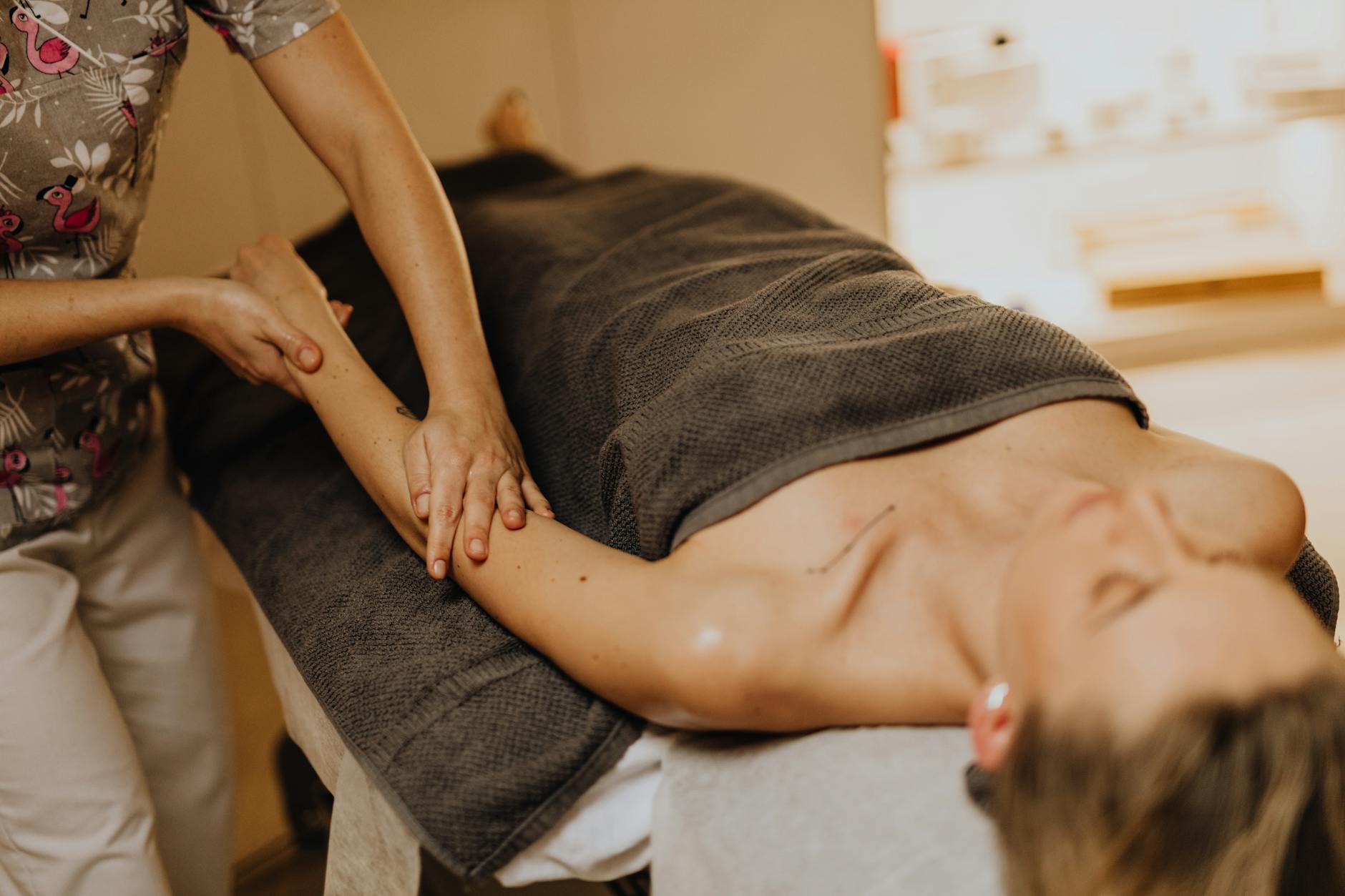Kobieta w spa podczas relaksującego masażu ramienia dla poprawy krążenia