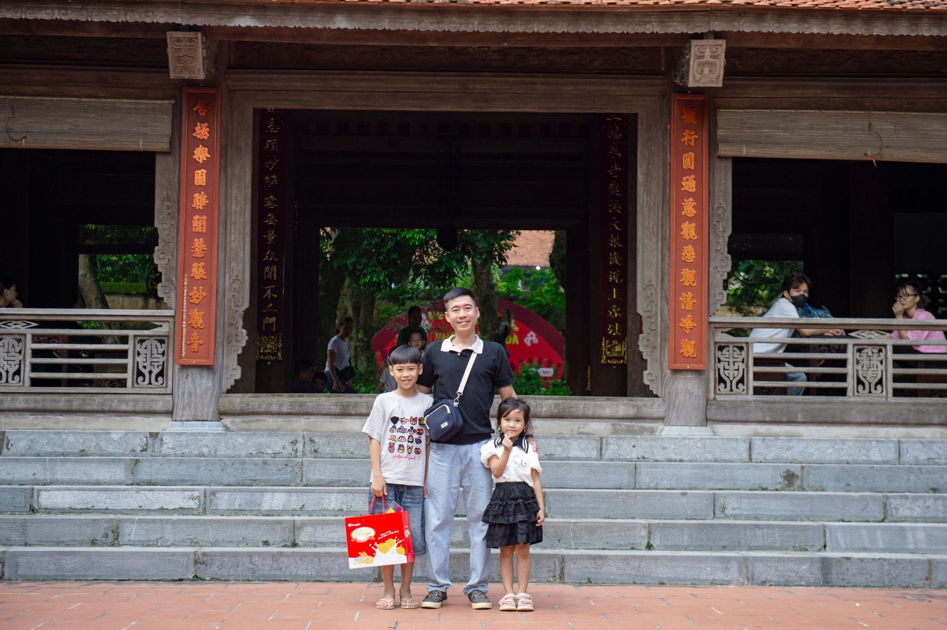 Rodzina z dzieckiem pozuje na tle zabytkowej architektury w Hanoi