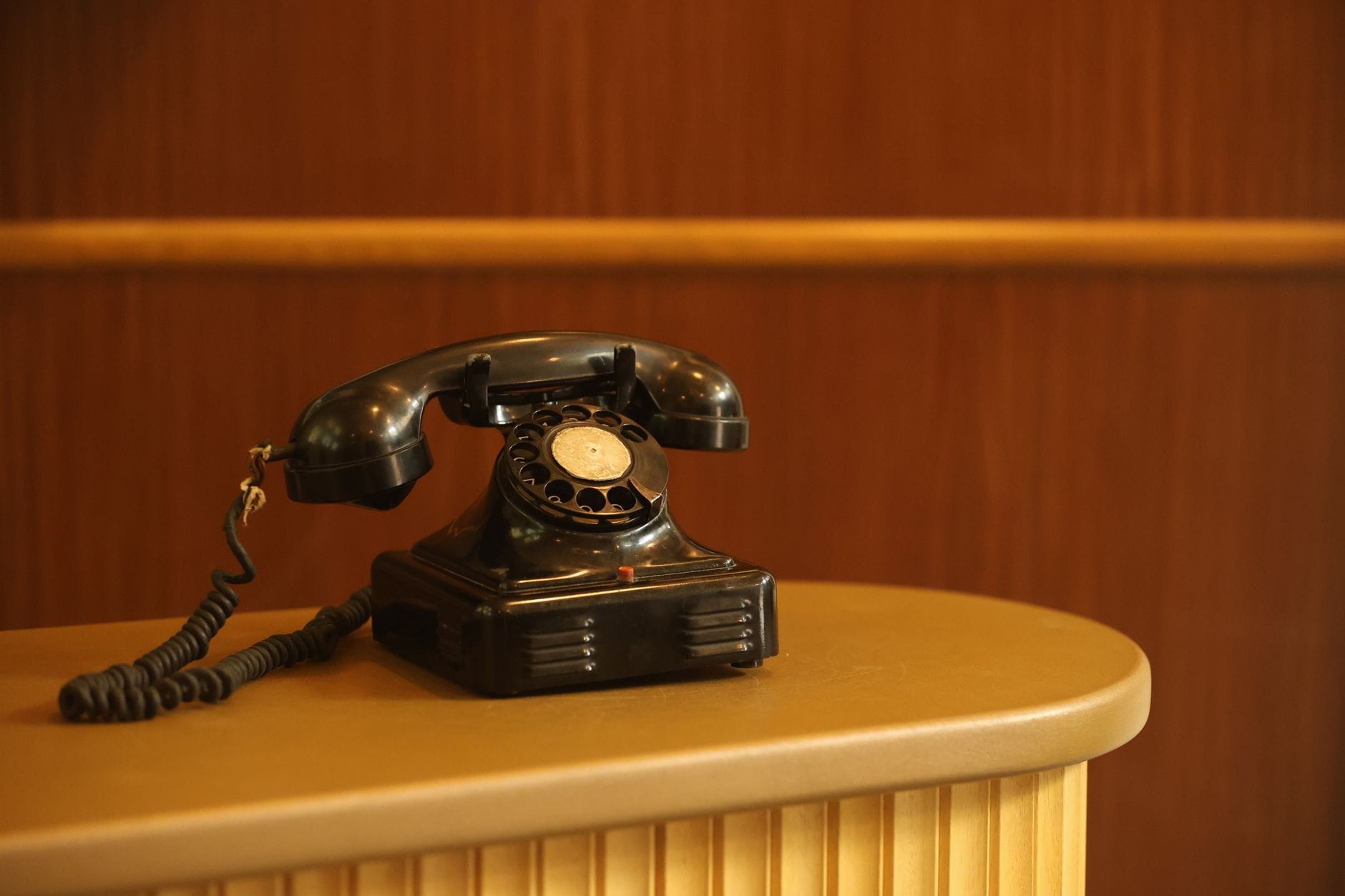 Czarny telefon z tarczą na ladzie recepcji hotelu